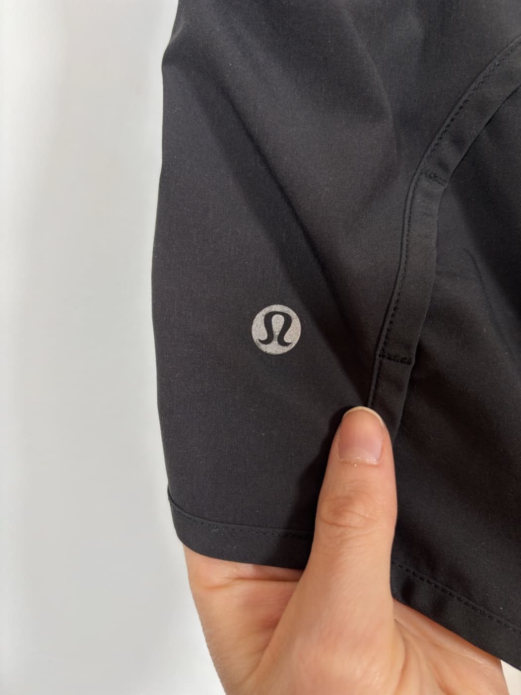 Close-up of the reflective Lululemon logo on the shorts.